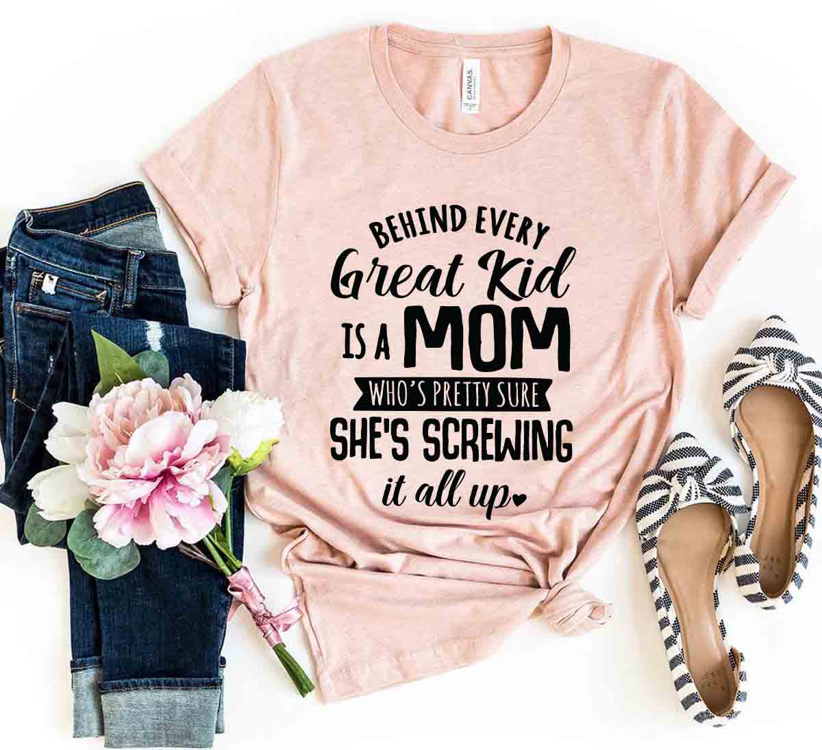 DT0283 Behind Every Great Kid Is A Mom Shirt in various colors, showcasing its soft fabric and stylish design.