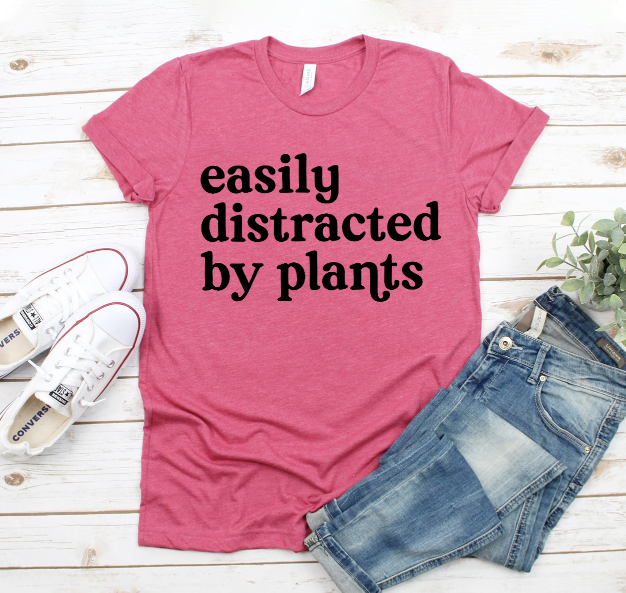 Easily Distracted By Plants T-shirt displayed on a hanger, showcasing its unisex design and soft fabric.