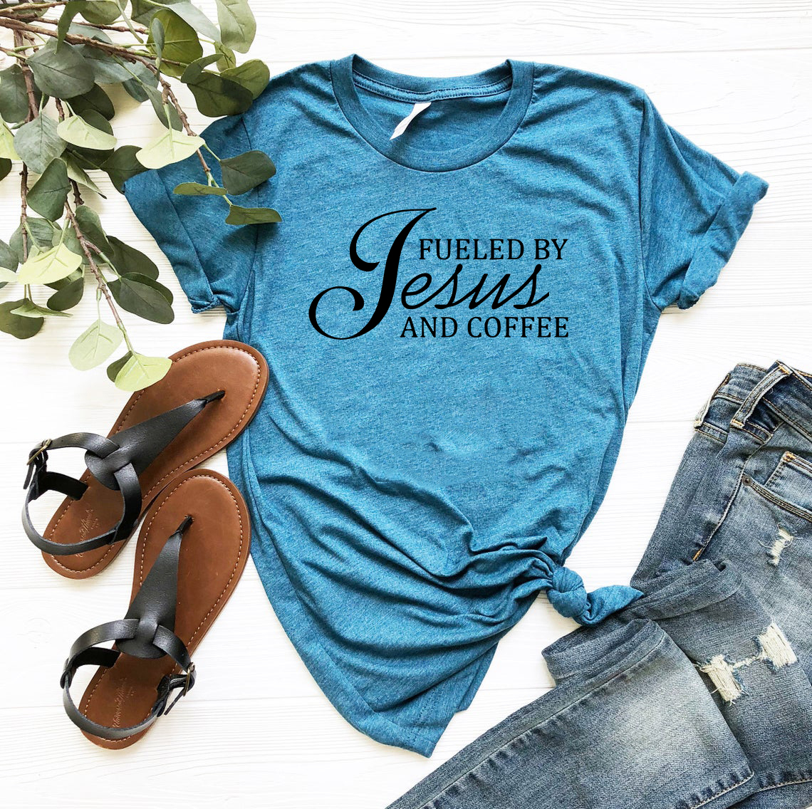 A comfortable unisex T-shirt featuring the phrase 'Fueled By Jesus And Coffee' in stylish print, available in multiple colors.