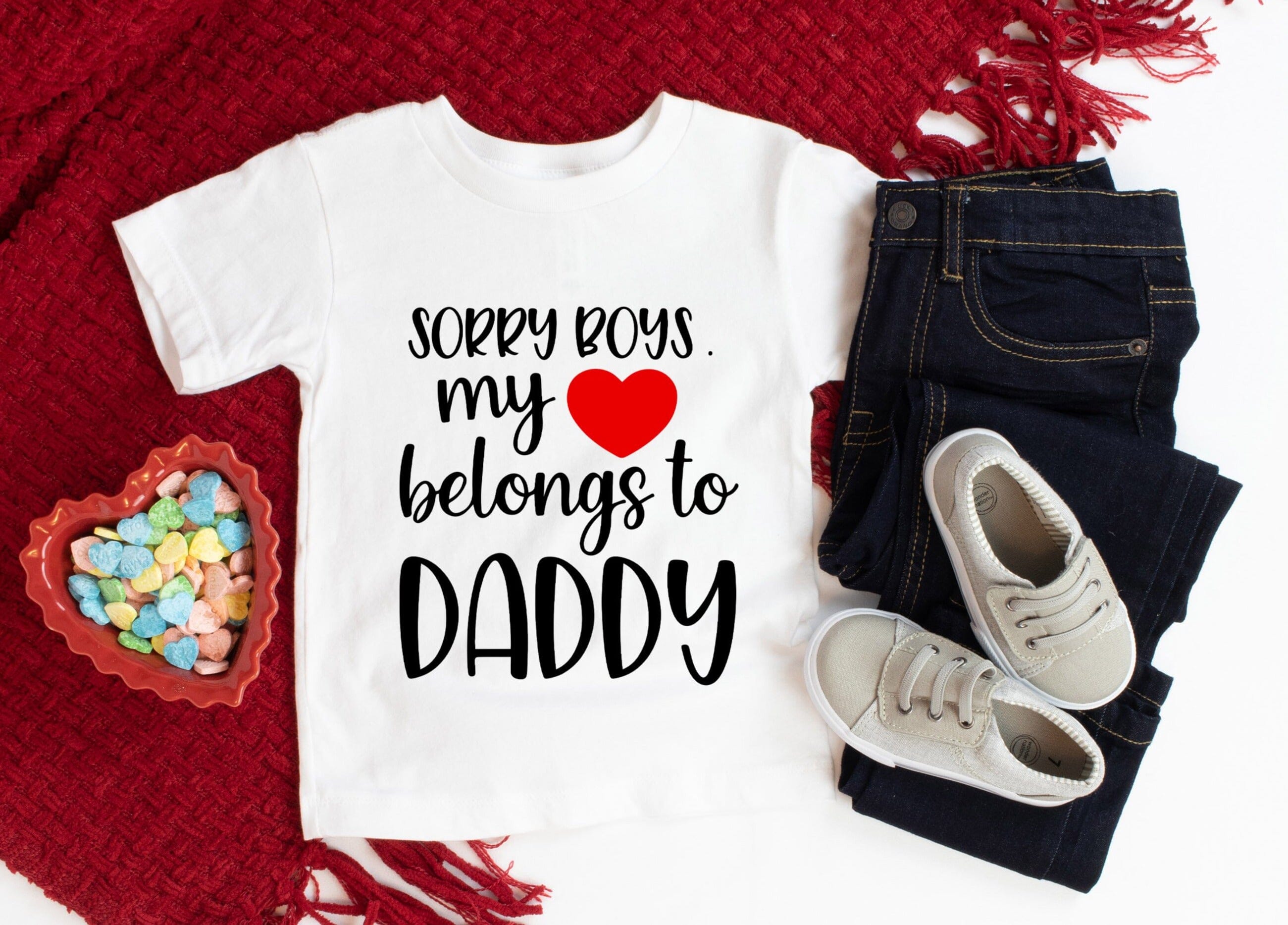 A cute baby wearing a Heart Belongs To Daddy Onesie, showcasing its soft fabric and playful design.