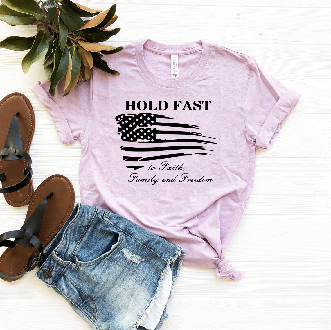 A unisex T-shirt featuring the phrase 'Hold Fast To Faith, Family And Freedom' printed on a soft, ring spun cotton fabric, available in multiple colors.