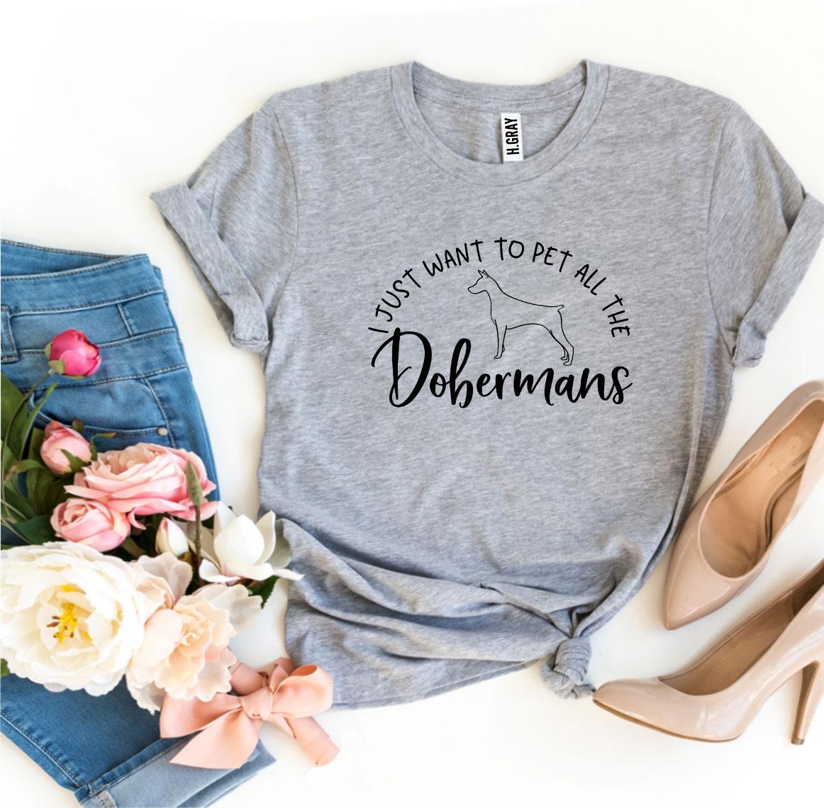 A soft and stylish t-shirt featuring the phrase 'I Just Want To Pet All The Dobermans', made from premium ring spun cotton.