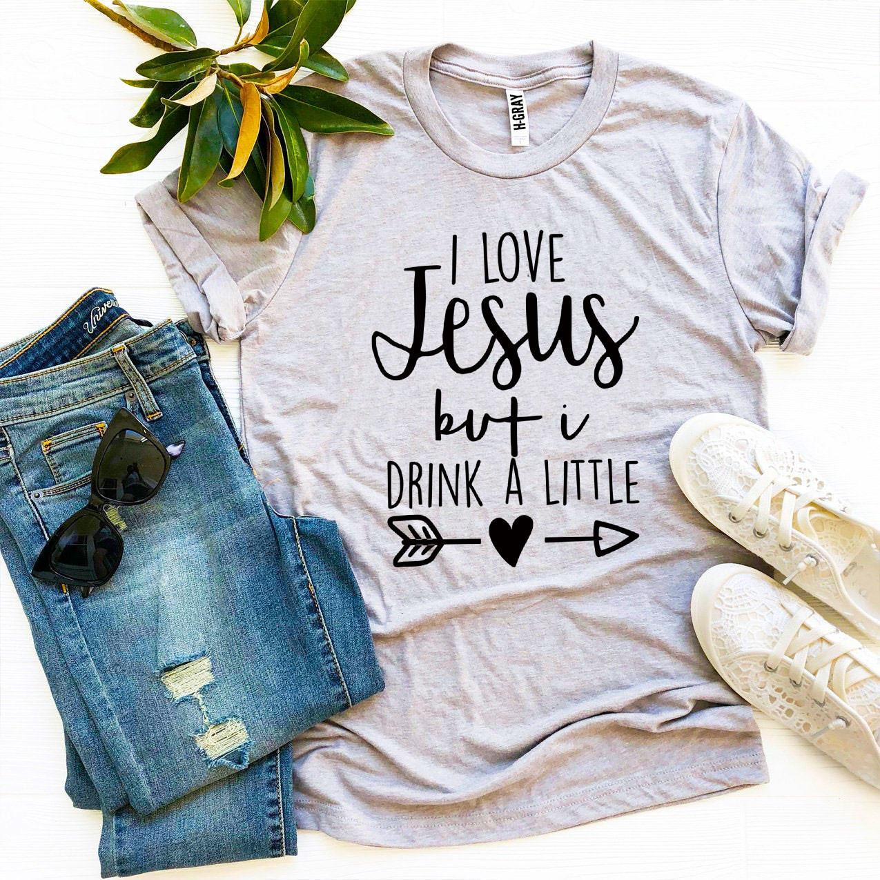 I Love Jesus But I Drink a Little T-shirt in various sizes, showcasing its soft cotton fabric and vibrant print design.