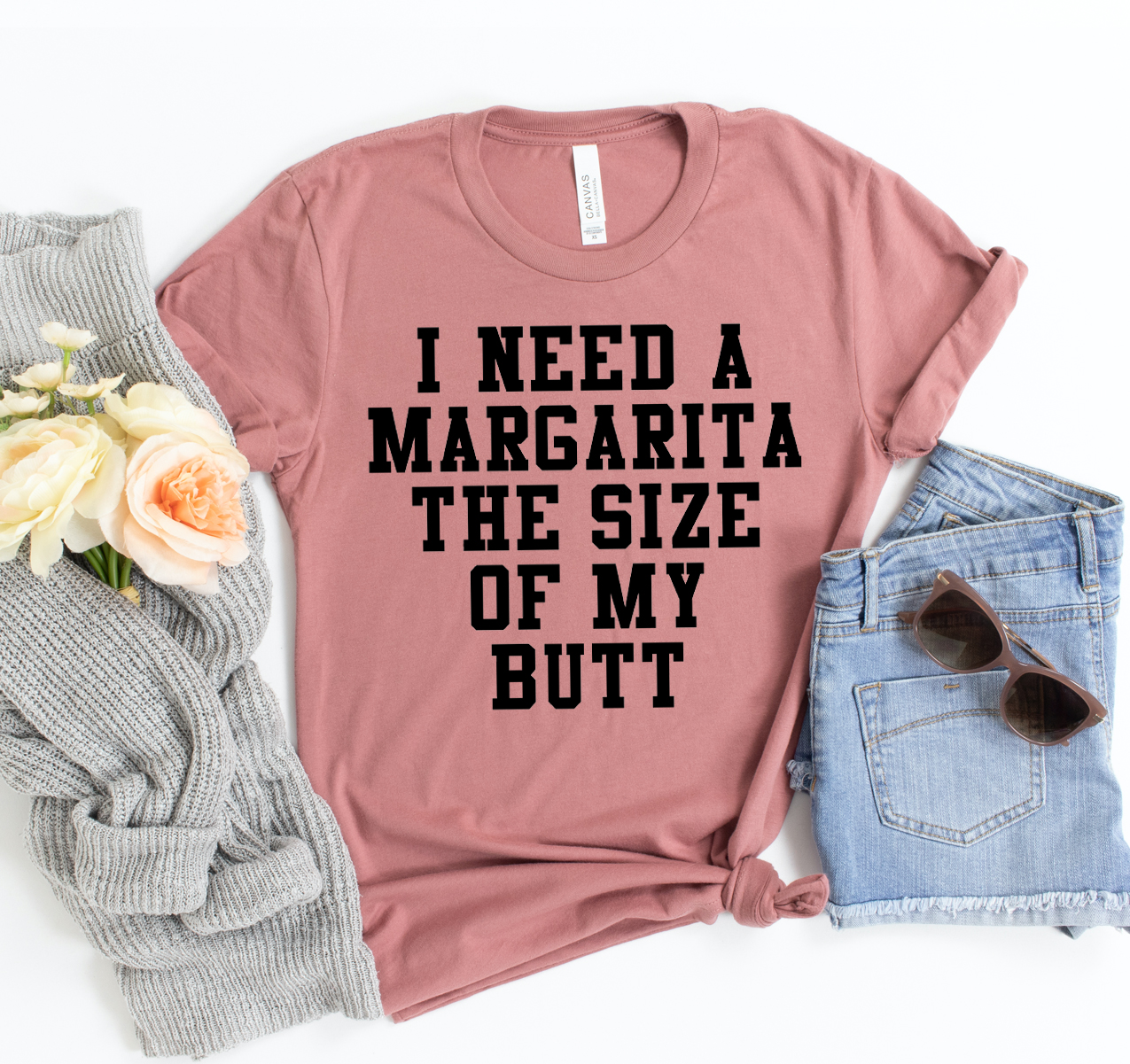 A humorous unisex t-shirt featuring the phrase 'I Need A Margarita & The Size Of My Butt' printed on a soft cotton fabric.