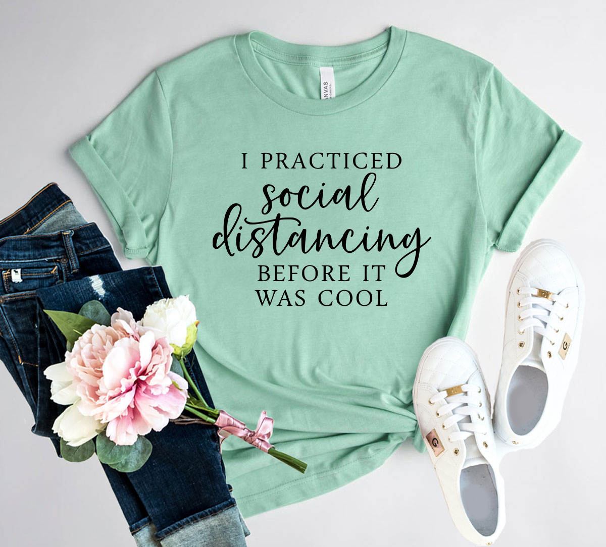 Unisex T-shirt featuring the phrase 'I Practiced Social Distancing Before' in a stylish design, available in multiple colors.