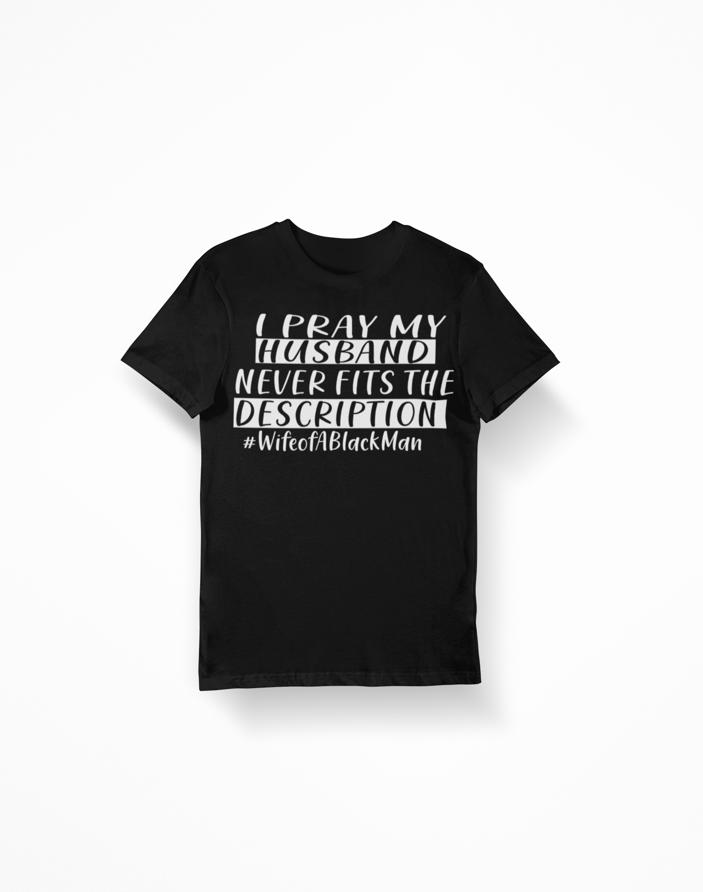 A humorous women's shirt featuring the phrase 'I Pray My Husband Never Fits The Description' printed on a classic fit Gildan shirt.