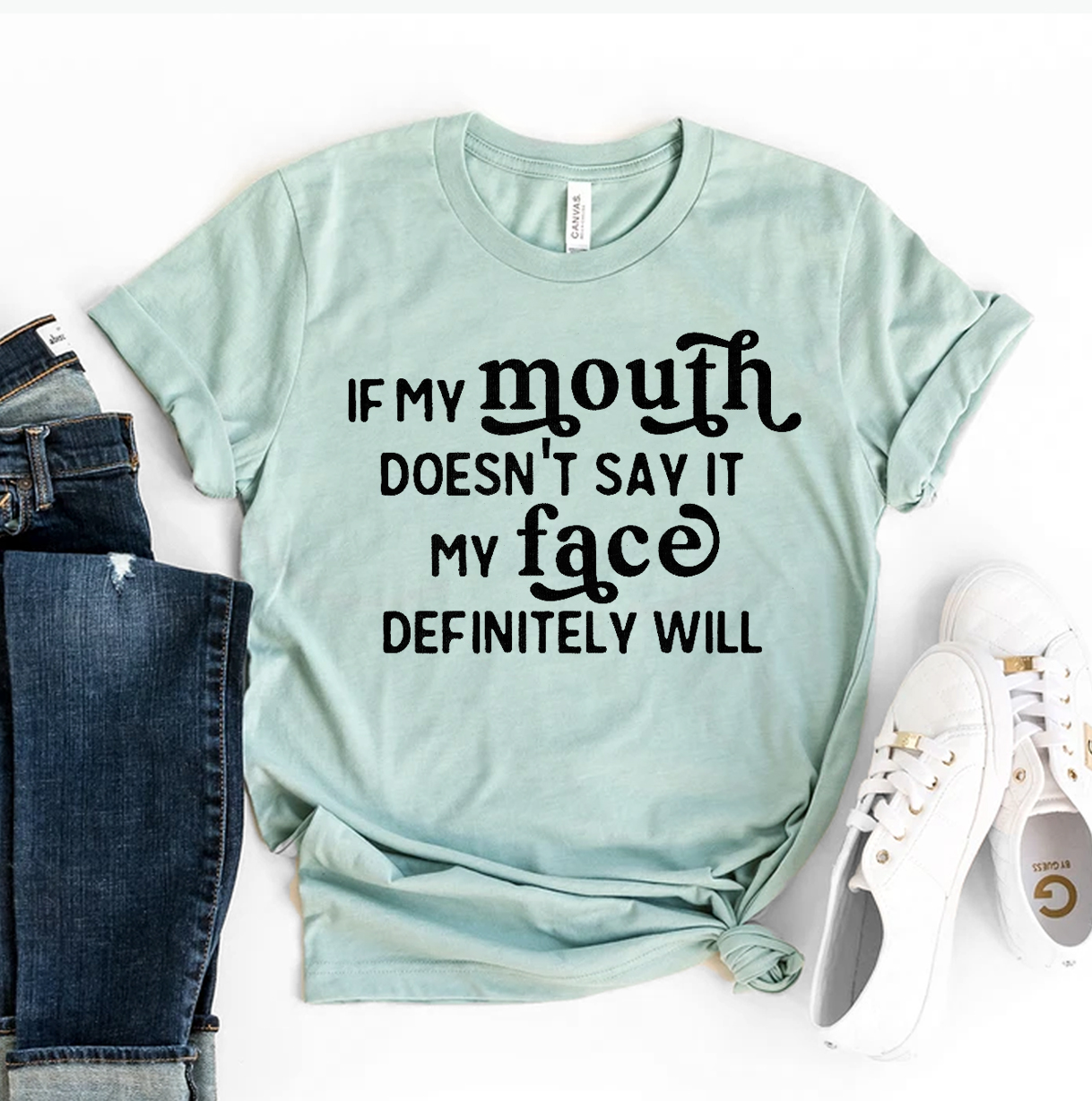 A stylish black t-shirt featuring the phrase 'If My Mouth Doesn't Say It My Face Definitely Will' in bold white text, made from premium cotton.