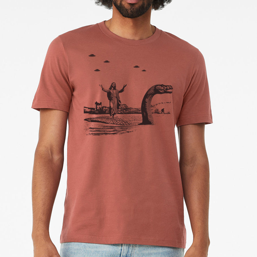 Men's T-shirt featuring Jesus Christ riding the Loch Ness Monster, hand printed with eco-friendly ink.