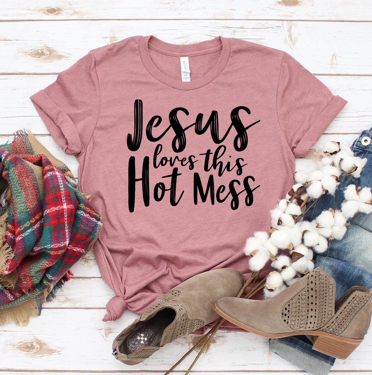 Jesus Loves This Hot Mess T-shirt made of premium ring spun cotton, featuring a humorous design and comfortable fit, available in various sizes.