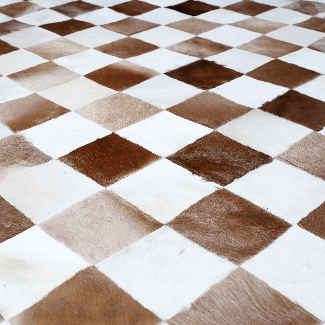 Hand-stitched leather rug made from genuine cowhide with a zigzag patchwork design, showcasing its luxurious texture and quality.