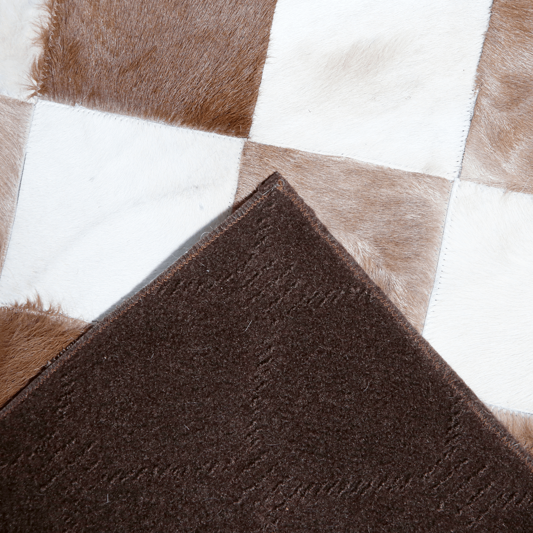 Hand-stitched leather rug made from genuine cowhide with a zigzag patchwork design, showcasing its luxurious texture and quality.