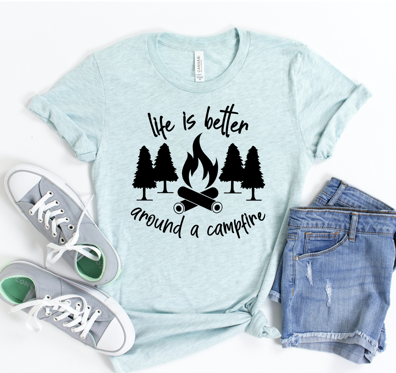 Unisex 'Life Is Better Around Campfire' T-shirt displayed on a wooden background, showcasing its soft fabric and classic design.
