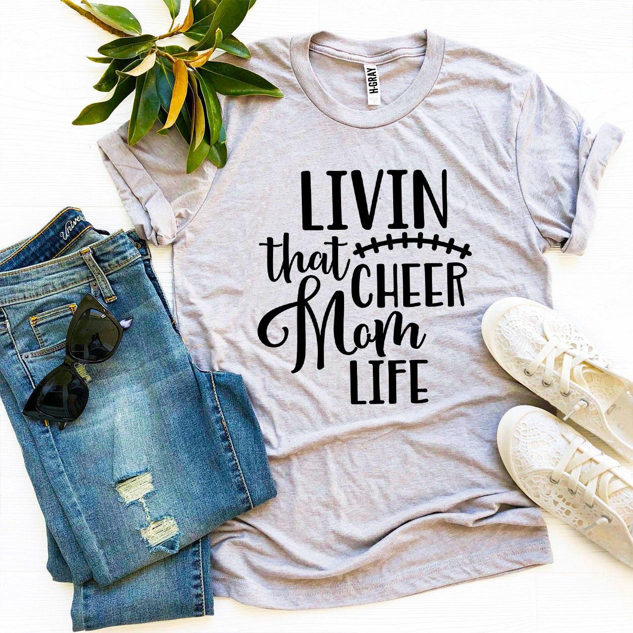 Livin That Cheer Mom Life T-shirt in premium ring spun cotton with a stylish design, available in multiple sizes.