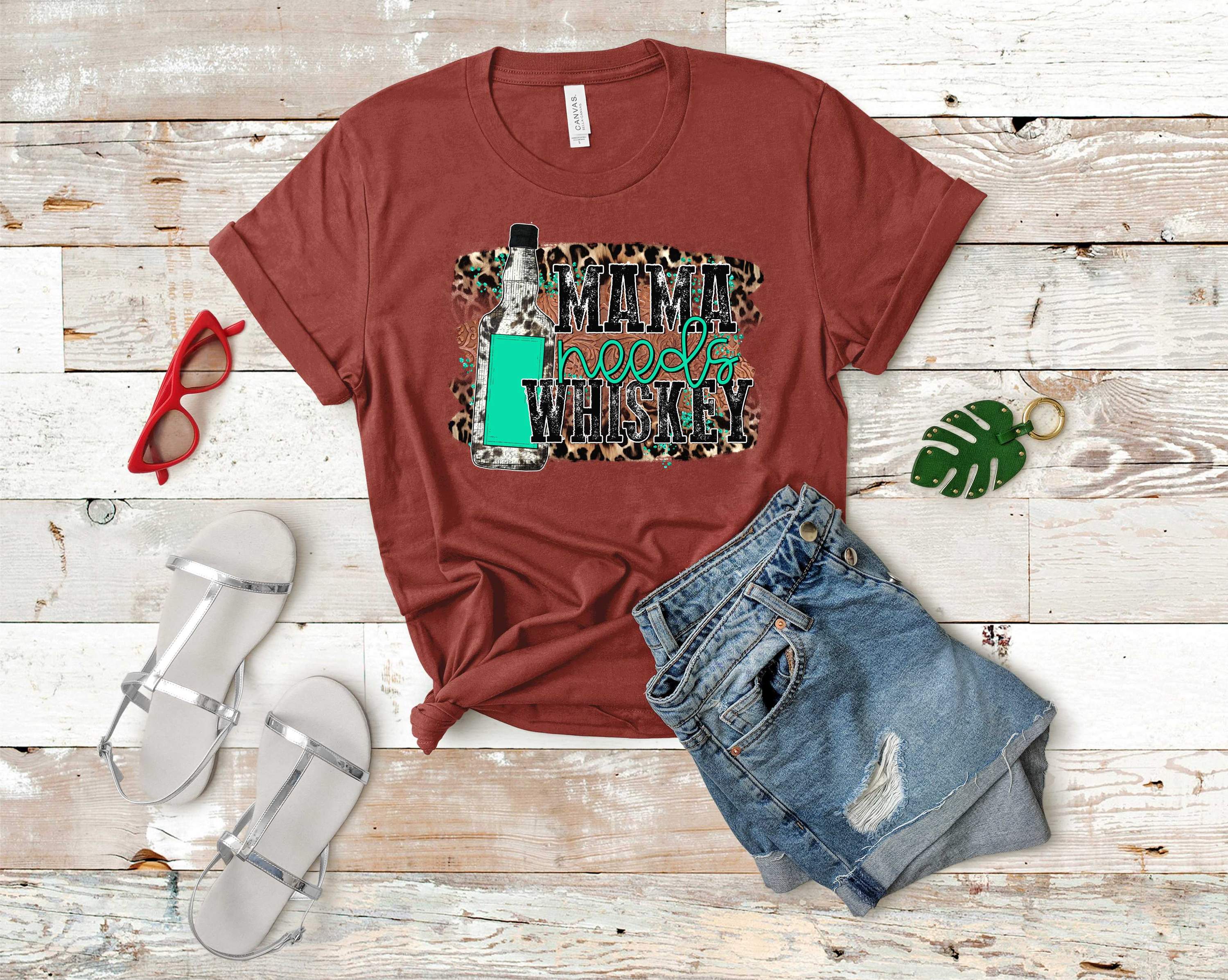 Mama Needs Whiskey graphic tee in various colors, showcasing a stylish design with a fun phrase.