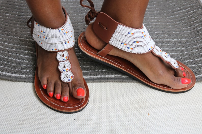 A pair of handmade Maasai African sandals featuring colorful beadwork and soft leather, perfect for summer wear.