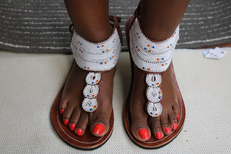 A pair of handmade Maasai African sandals featuring colorful beadwork and soft leather, perfect for summer wear.