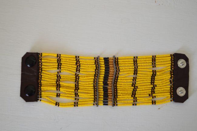 Maasai Beaded Cuff Bracelet featuring vibrant yellow African beads and durable leather, showcasing a unique multi-strand design.