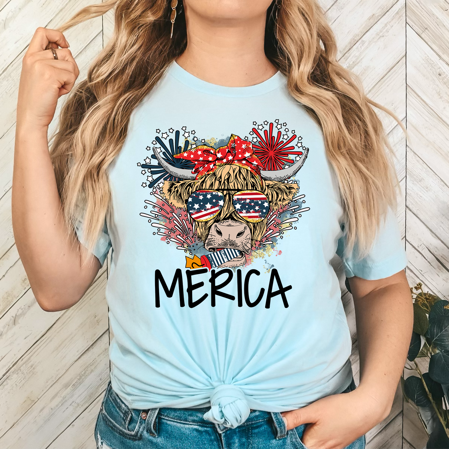A unisex T-shirt featuring a colorful cow design with patriotic elements, perfect for casual wear.