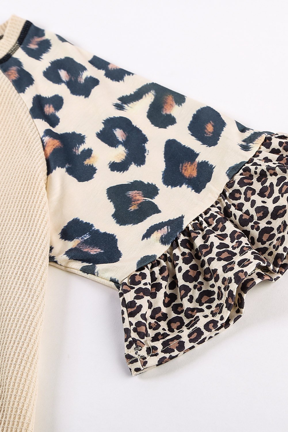 A stylish Mixed Leopard Ruffle Sleeve Waffle V Neck Knit Top featuring a v-neckline, ruffle sleeves, and a bold leopard print design.