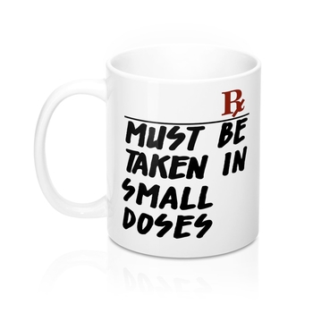 A white ceramic mug with rounded corners and a C-handle, featuring the phrase 'Must Be Taken In Small Doses'.