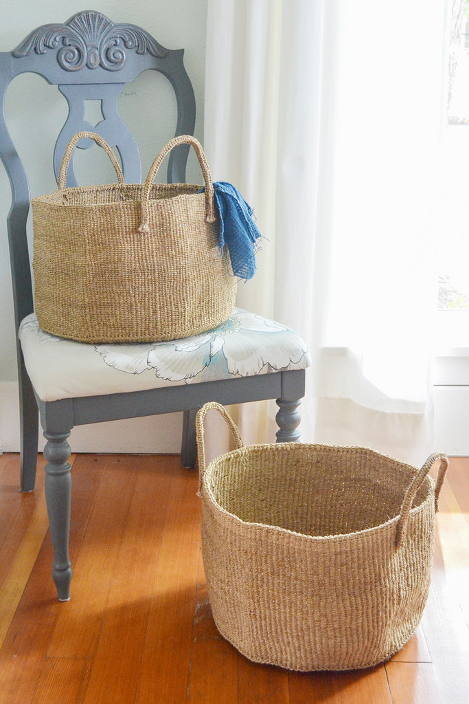 Handwoven natural sisal and fibre African floor storage baskets in cream color, showcasing their unique texture and design.