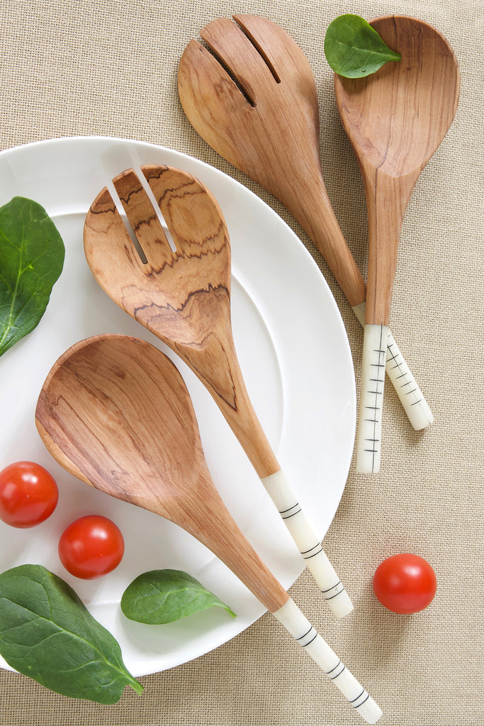 Handcrafted olive wood salad server with cow bone handles, featuring African line art etchings, showcasing natural beauty and craftsmanship.