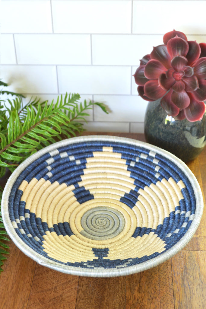 A beautifully crafted Rwanda handmade wall and storage basket made from natural sisal and banana fiber, showcasing intricate weaving patterns.