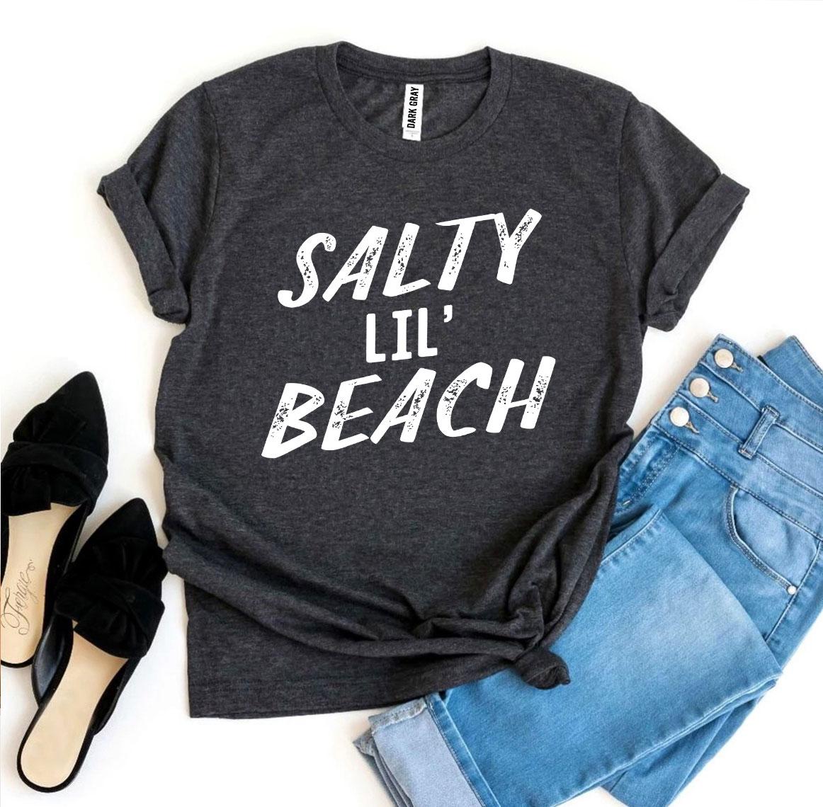 Salty Lil’ Beach T-shirt made from premium ring spun cotton, featuring a vibrant design and available in multiple sizes.