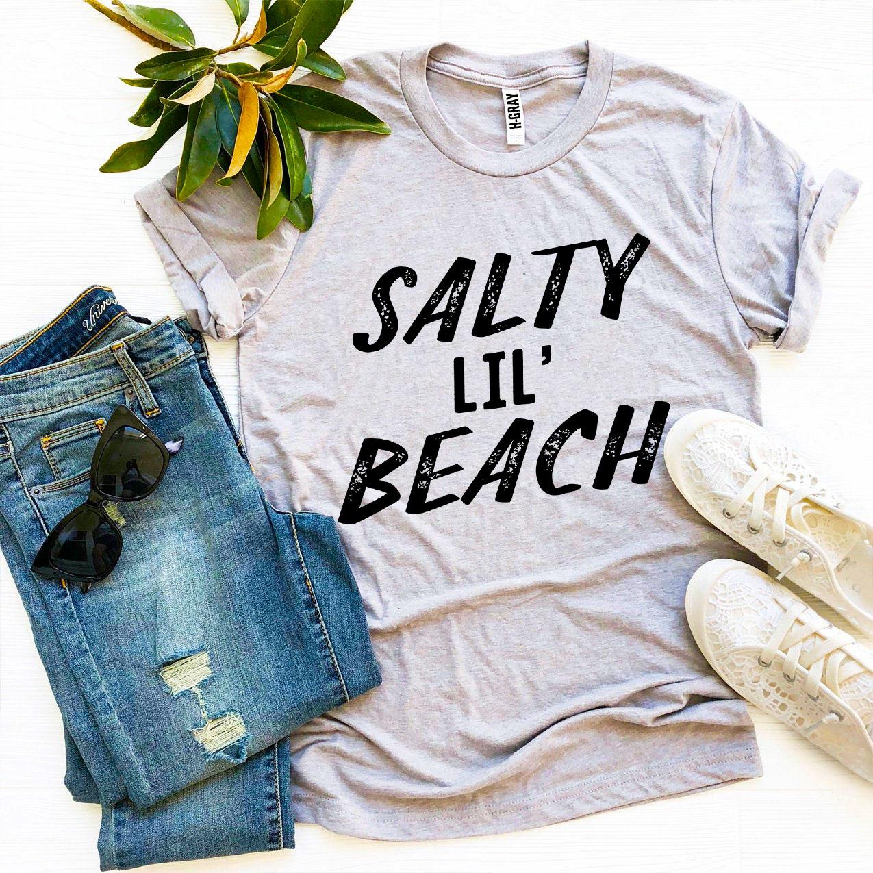 Salty Lil’ Beach T-shirt made from premium ring spun cotton, featuring a vibrant design and available in multiple sizes.