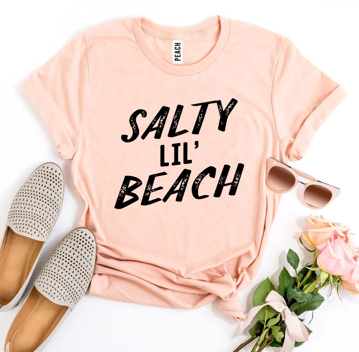 Salty Lil’ Beach T-shirt made from premium ring spun cotton, featuring a vibrant design and available in multiple sizes.