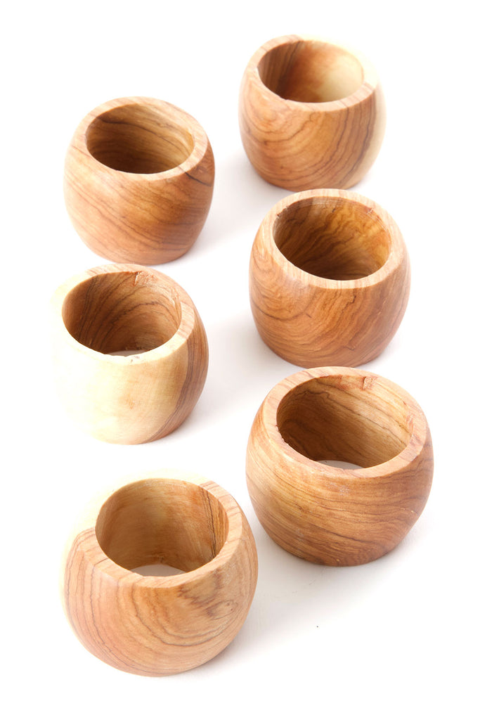 Set of 4 hand carved olive wood napkin rings showcasing unique grain patterns and smooth finish.