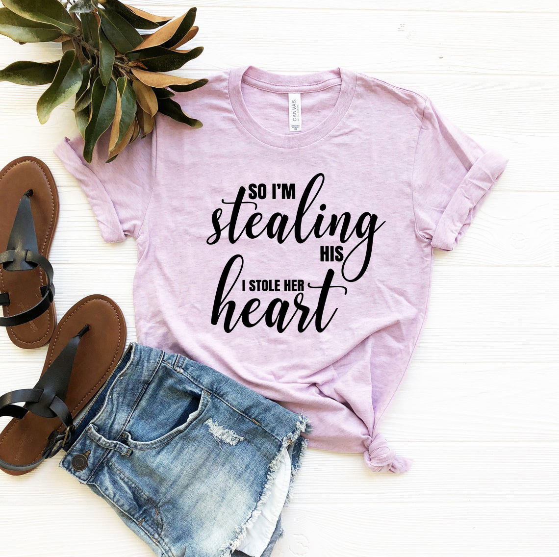 A stylish unisex T-shirt featuring the phrase 'So I'm Stealing His Heart' printed on it, available in various colors.