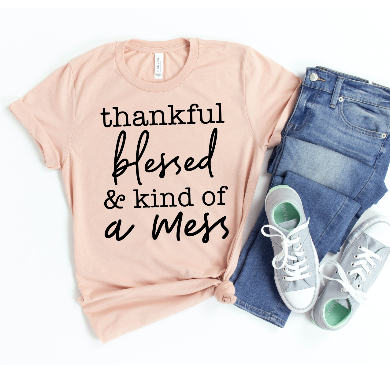 A comfortable unisex Thankful Blessed & Kind Of a Mess T-shirt displayed on a hanger, showcasing its soft fabric and trendy design.