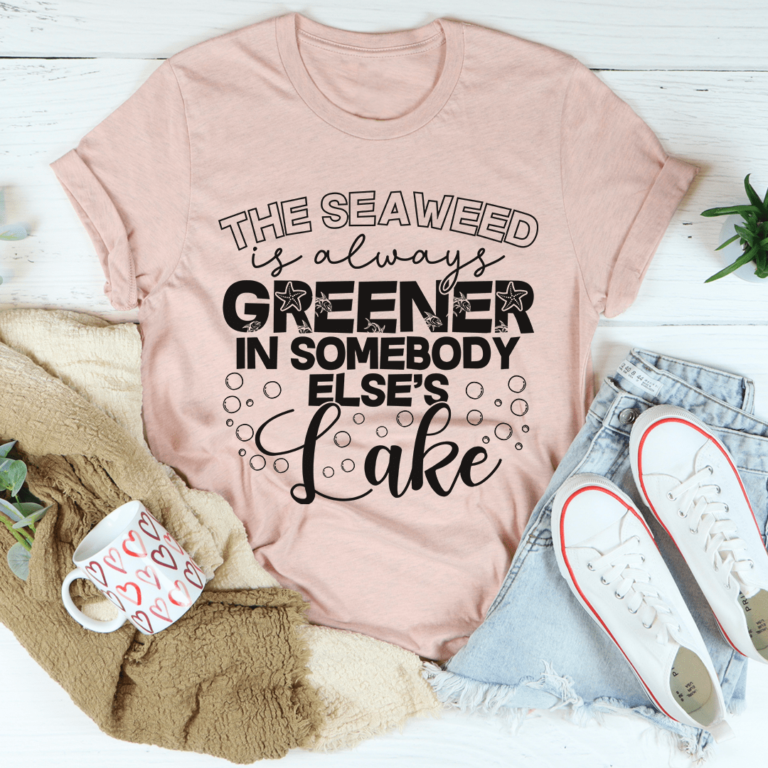 A classic unisex short sleeve tee featuring the phrase 'The Seaweed Is Always Greener In Somebody Else's Lake' in vibrant colors on soft cotton fabric.