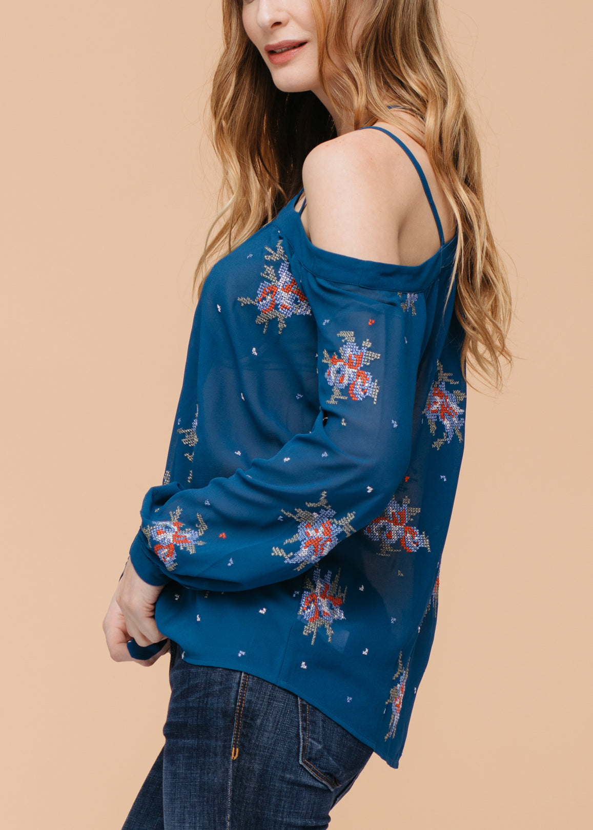 Off shoulder teal blouse with intricate embroidery print, showcasing a stylish and feminine design.