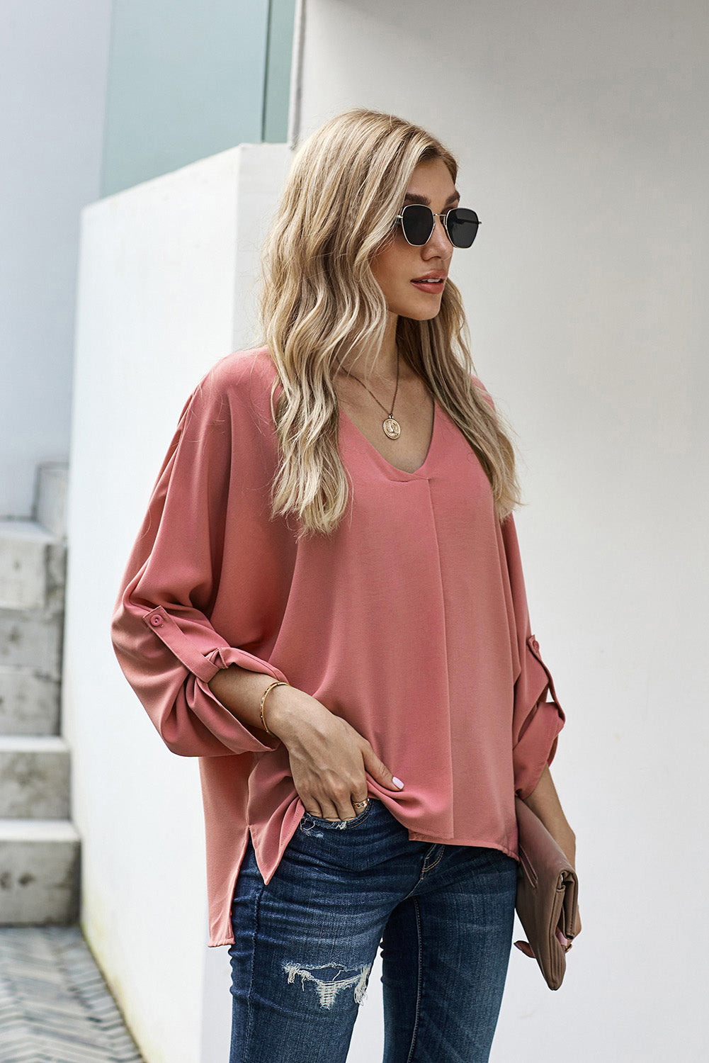 A stylish pink v-neck shirt with 3/4 sleeves and a high low hem, perfect for casual wear in spring and autumn.