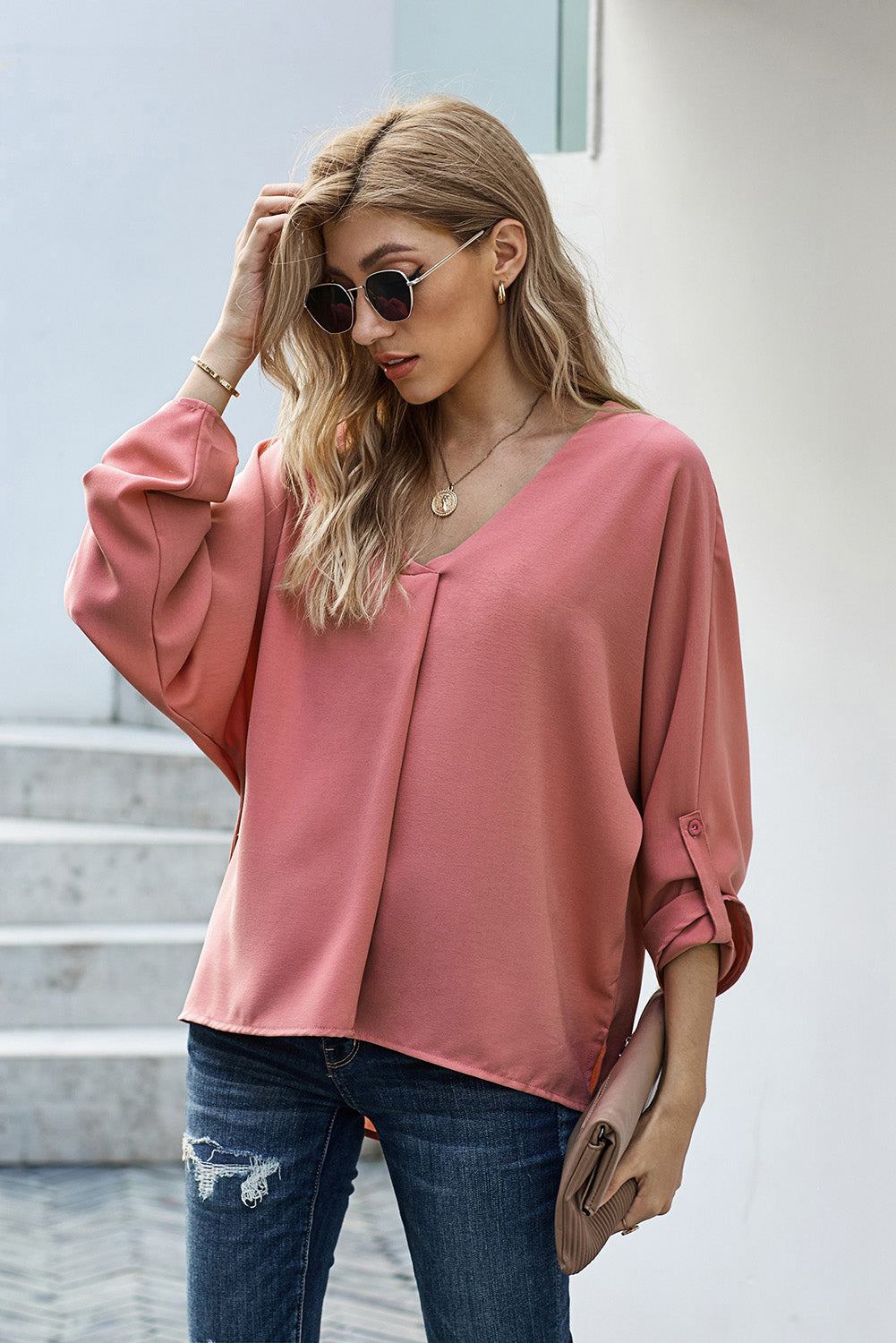 A stylish pink v-neck shirt with 3/4 sleeves and a high low hem, perfect for casual wear in spring and autumn.