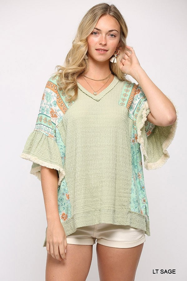 Light sage Texture Knit and Print Mixed Hi Low Hem Top with fringe trim sleeves and side slits, showcasing its unique design.