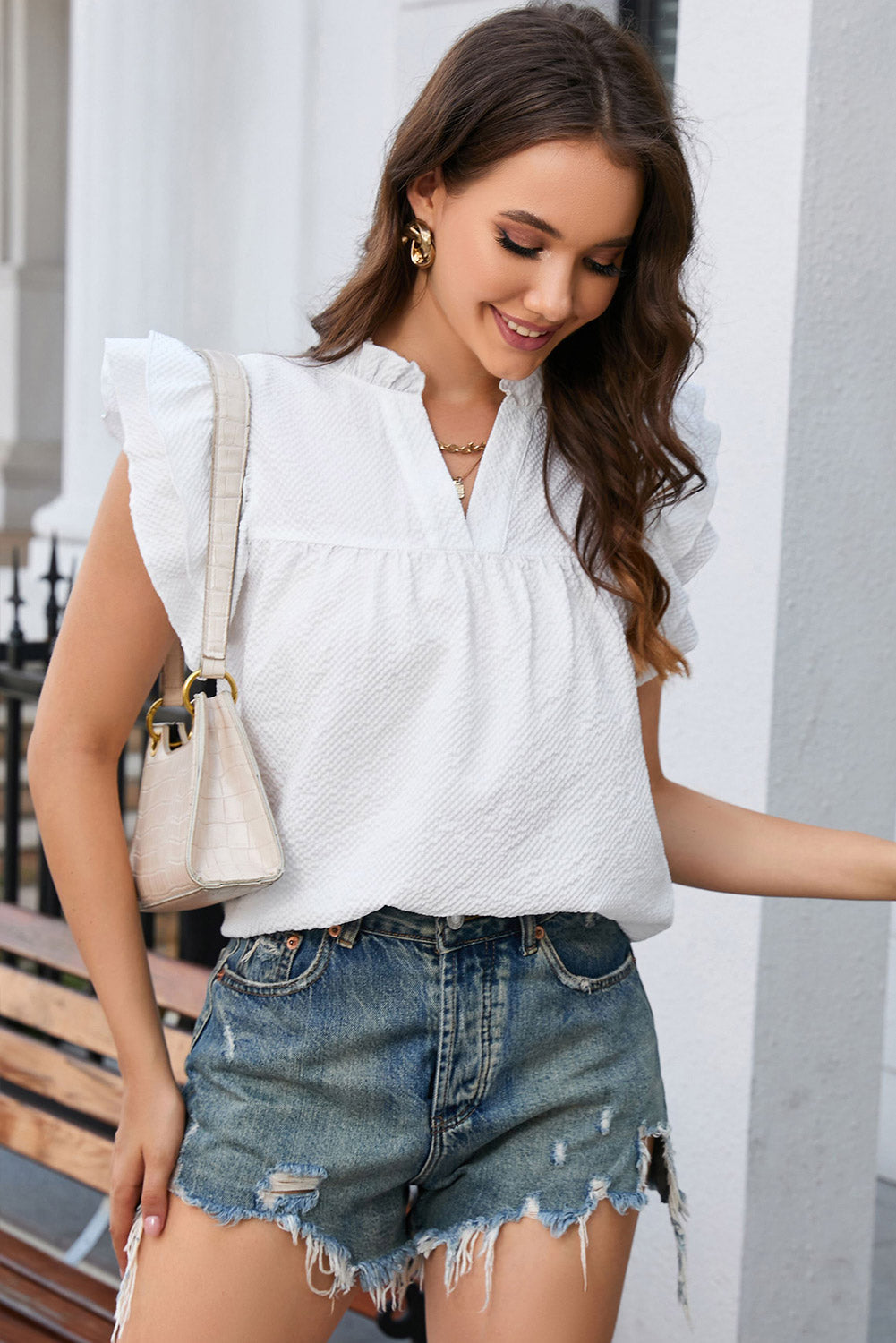 A stylish white top featuring ruffle accents and flutter sleeves, designed with a notch neck for an elegant look.