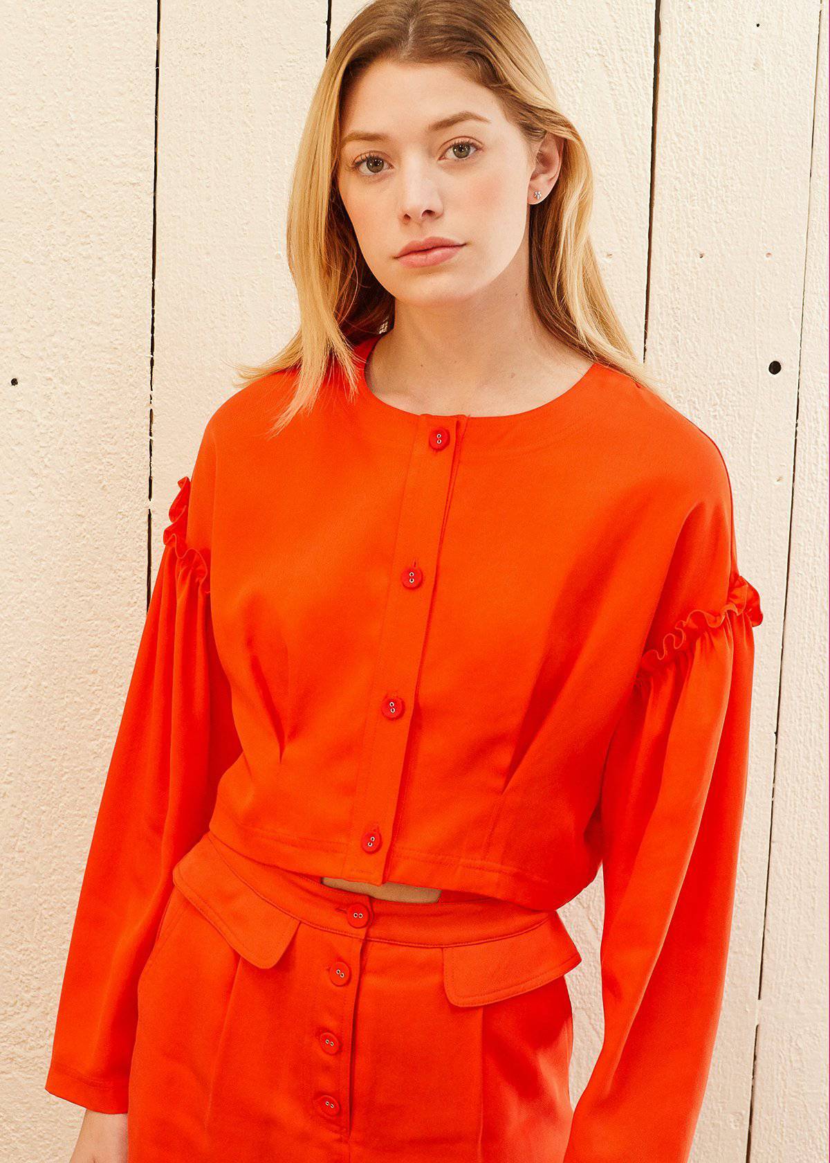 Women's Button Front Long Sleeve Crop Top in vibrant poppy color with drop shoulder and ruffle accent, showcasing button fly closure.