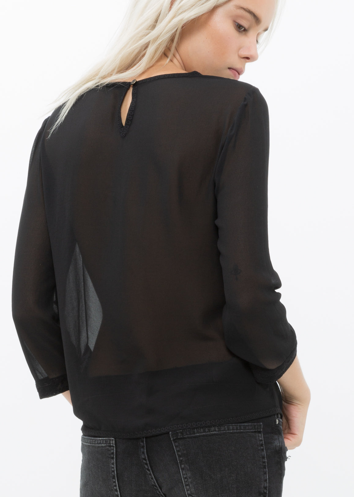 Women's black long sleeve sheer top with embossed front detail and lace panels.