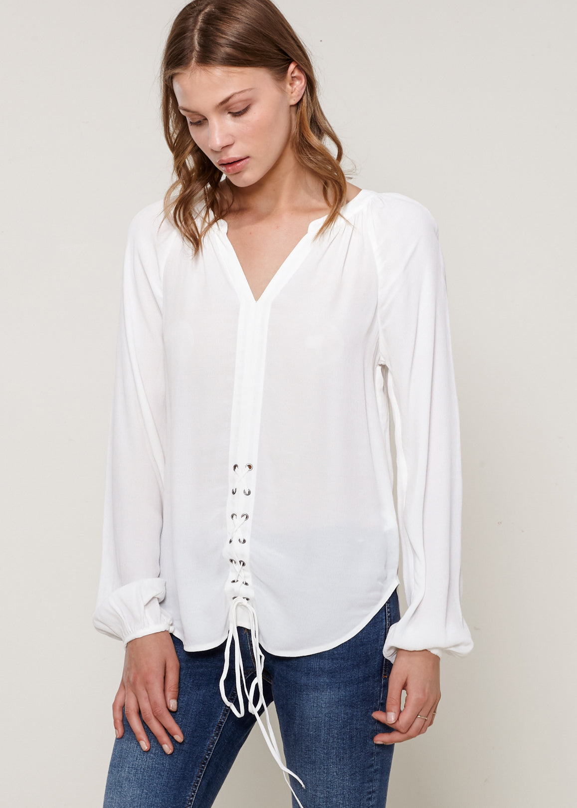 A stylish Women's Lace Up Blouse featuring a round split neck, self-tie lace-up front, and long sleeves with gathered cuffs, made from 100% viscose.