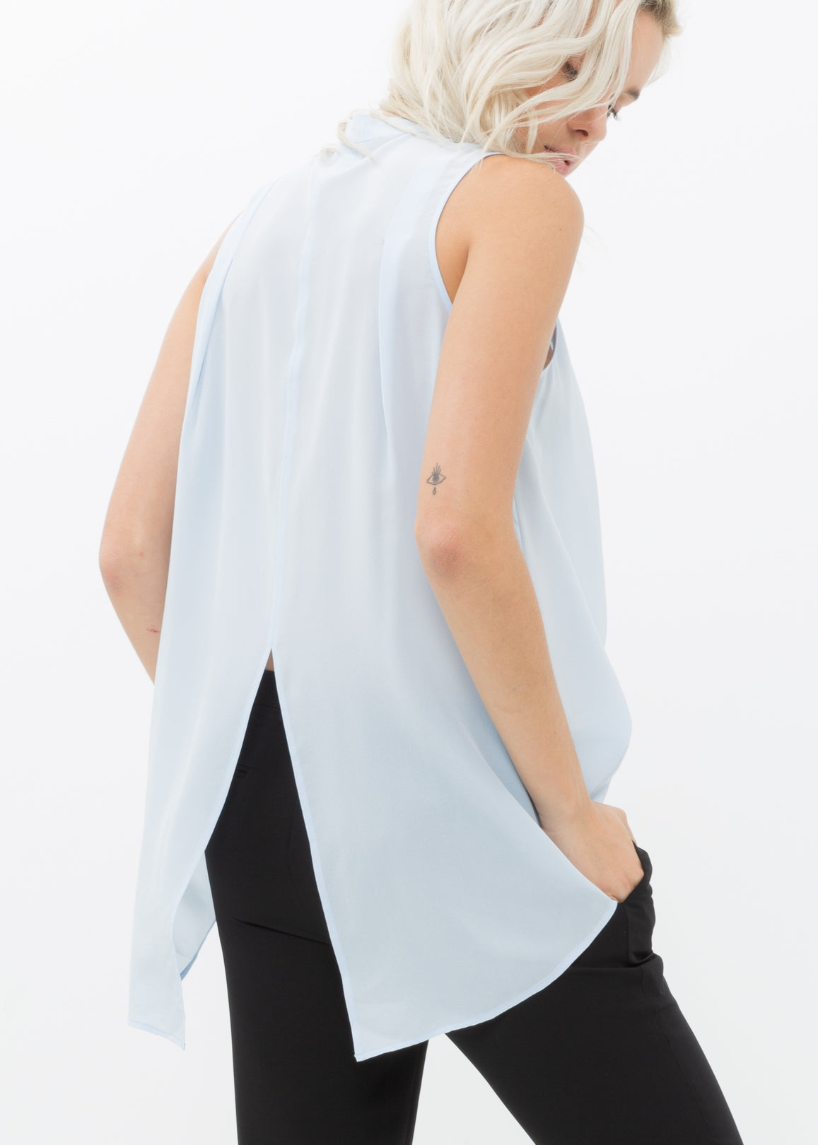 A stylish women's sleeveless mock neck sheer blouse made of 100% silk, featuring a button closure and elegant design.