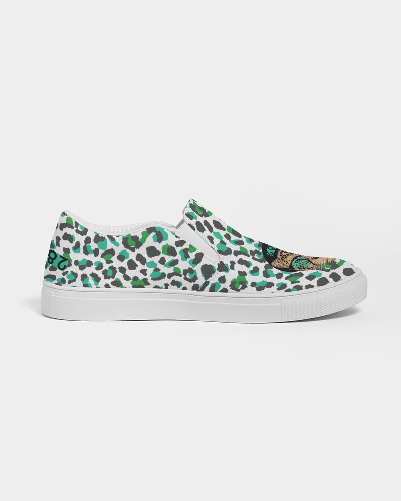 2882Sport™ Tropics of Oz Men's Cheetah Slip-On Canvas Shoes featuring a vibrant cheetah print and Shady Lion graphic.