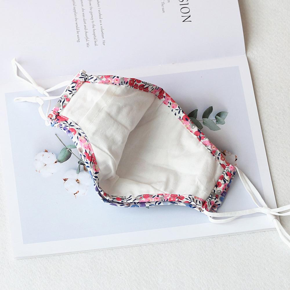 Two stylish Cherry Dream cotton face masks with nose wire and filter pocket, showcasing unique prints and adjustable ear loops.