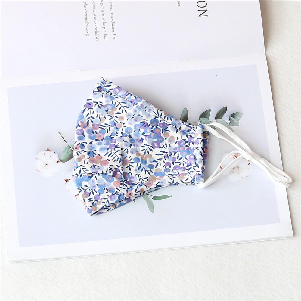 Two stylish Cherry Dream cotton face masks with nose wire and filter pocket, showcasing unique prints and adjustable ear loops.