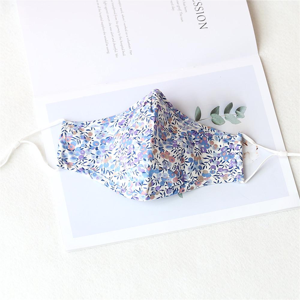 Two stylish Cherry Dream cotton face masks with nose wire and filter pocket, showcasing unique prints and adjustable ear loops.