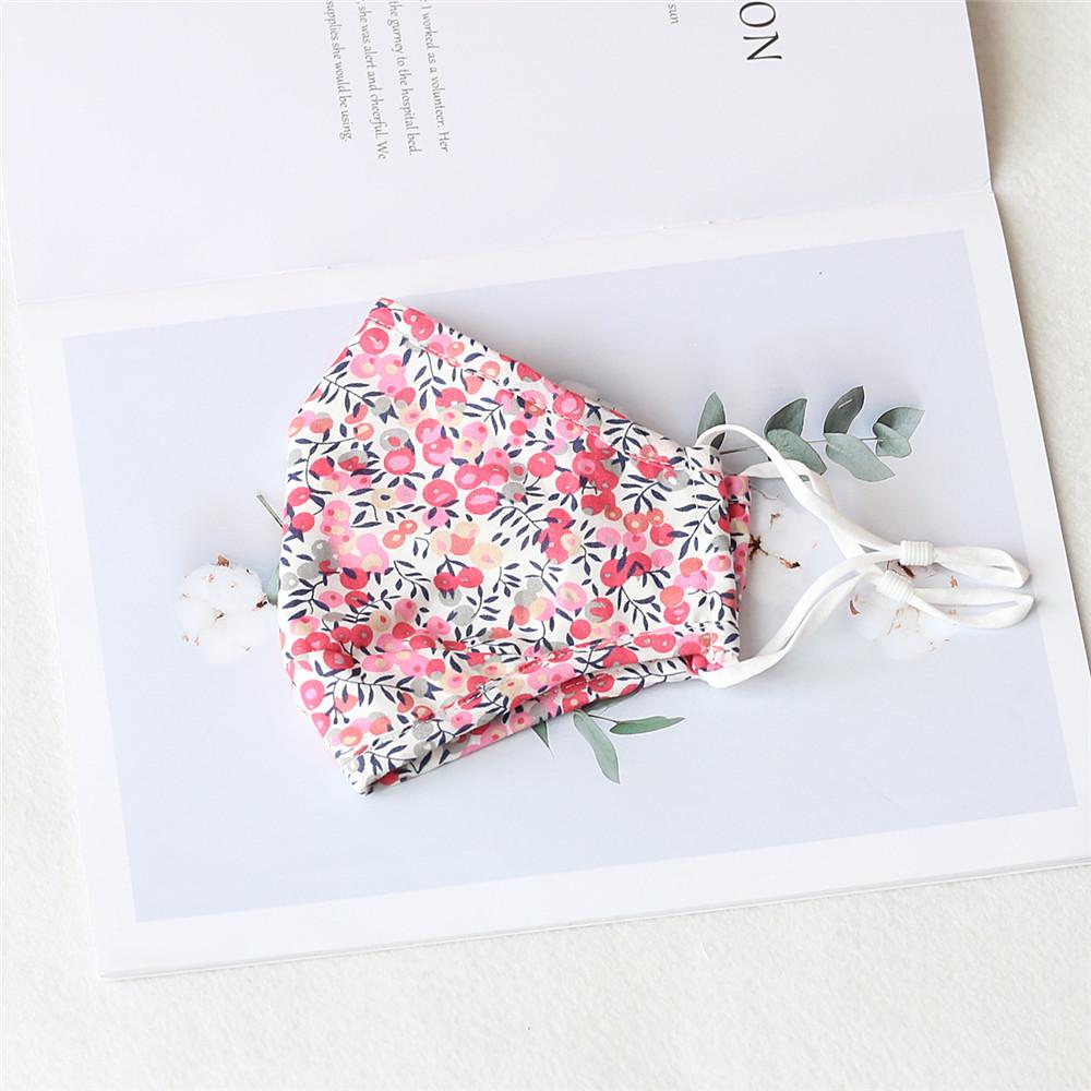 Two stylish Cherry Dream cotton face masks with nose wire and filter pocket, showcasing unique prints and adjustable ear loops.