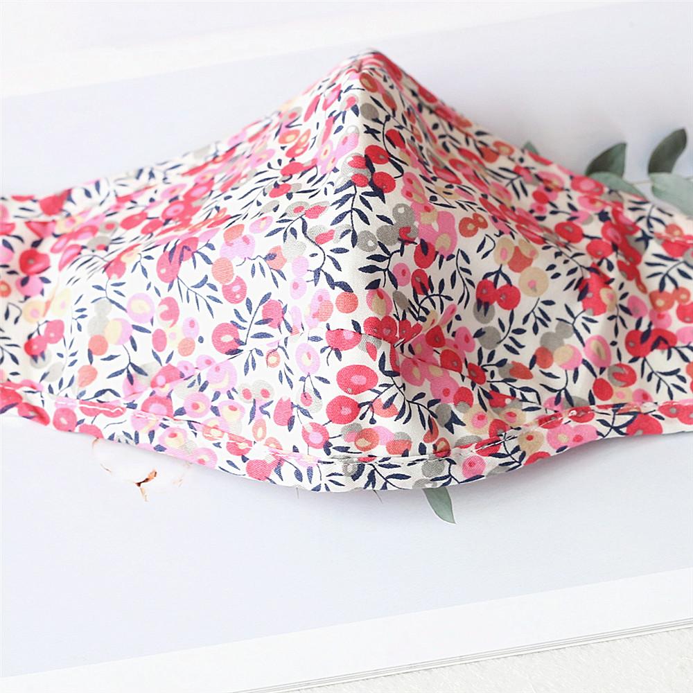 Two stylish Cherry Dream cotton face masks with nose wire and filter pocket, showcasing unique prints and adjustable ear loops.