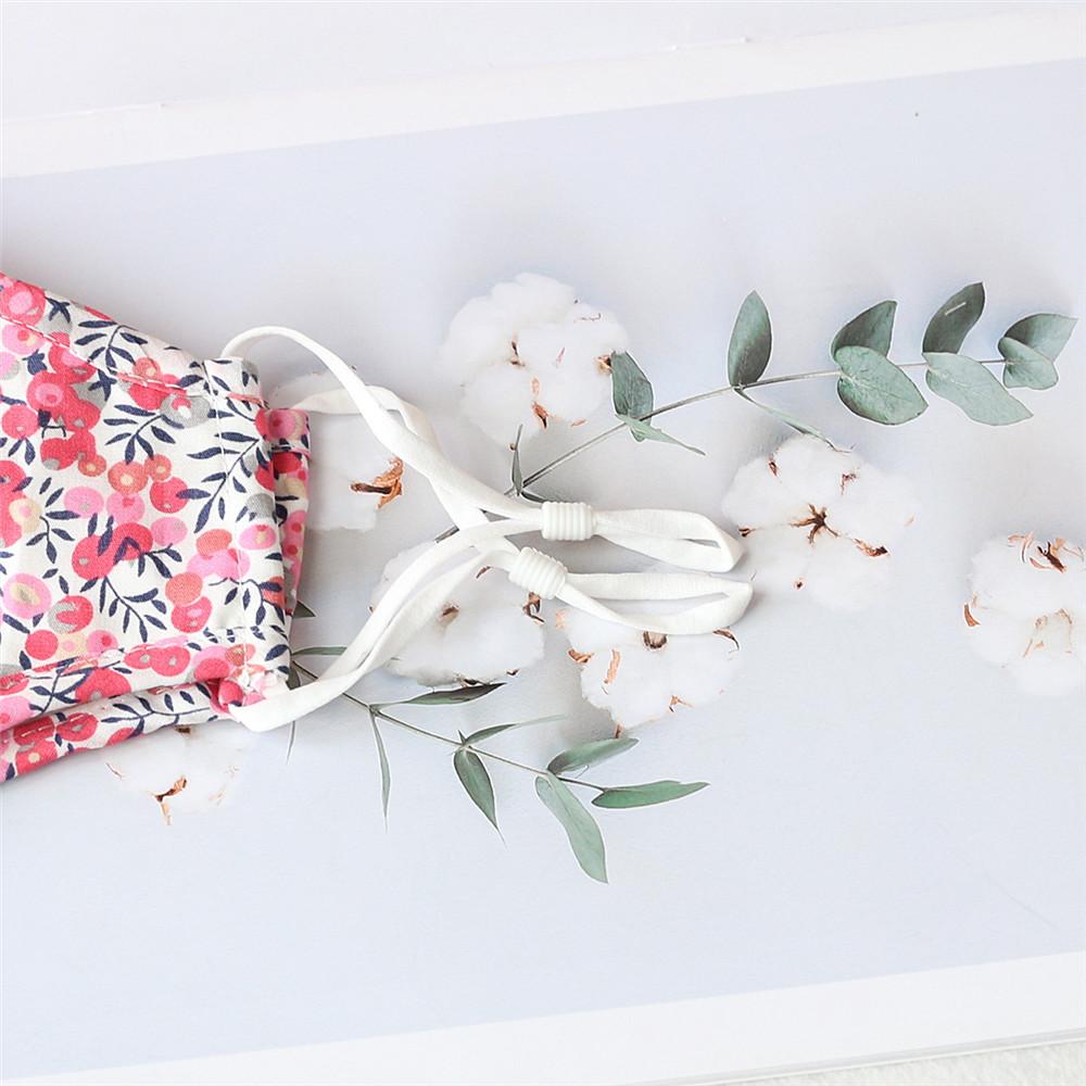 Two stylish Cherry Dream cotton face masks with nose wire and filter pocket, showcasing unique prints and adjustable ear loops.